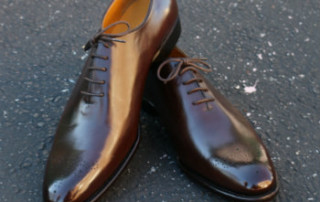 brown wholecut shoes on concrete
