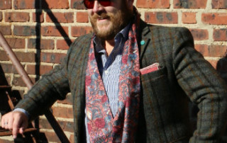man in red paisley scarf and sport coat